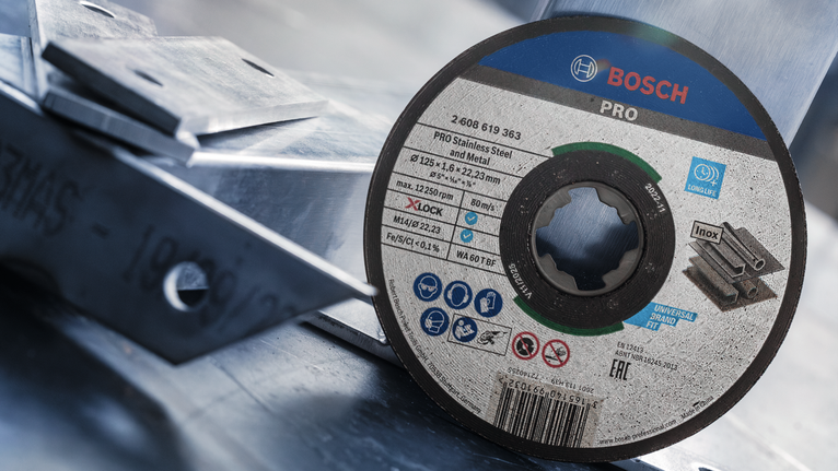 PRO Stainless Steel and Metal Bonded Cutting Disc, 125 x 1.6 x 22.23 mm, X-Lock, Straight, oSa Metal cutting disc leaning against stacked metal beams.