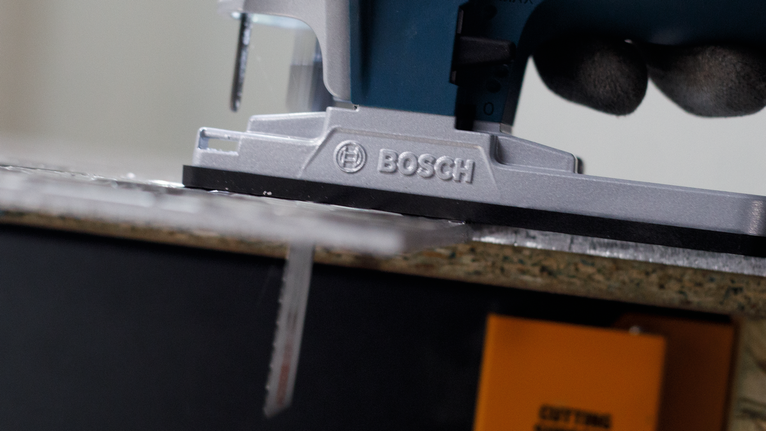 PRO Alu T127D Jigsaw Blade, 100 mm, 5 pcs Person wearing safety equipment guides a jigsaw to cut through a wood board.