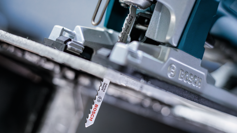 PRO Alu curve T227D Jigsaw Blade, 100 mm, 5 pcs Close-up of a jigsaw blade cutting through a metal sheet.