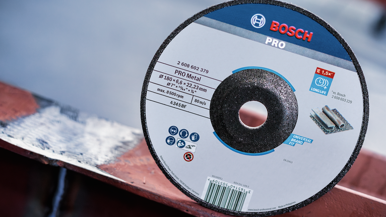 PRO Metal Grinding Disc, A 24 S BF, 180 x 6.6 x 22.23 mm, Depressed Centre Metal cutting disc resting on a painted metal surface outdoors.