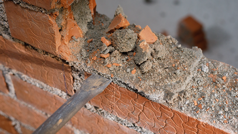 PRO SDS max-4C Flat Chisel, 25 x 600 mm Chisel removing mortar and bricks from a damaged brick wall.