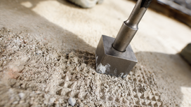 Chisel tool breaking concrete surface.