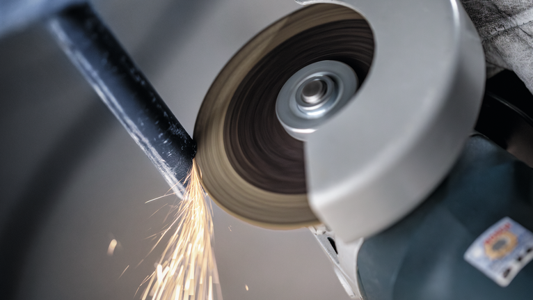 PRO Metal Cutting Disc, 100 x 2.5 x 16 mm Angle grinder cutting through metal, producing bright sparks.