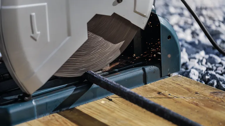 PRO Metal Cutting Disc, 355 x 3 x 25.4 mm Cut-off saw slicing through a metal rod on a wooden platform.