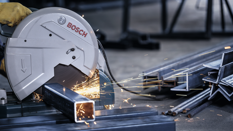 PRO Metal Cutting Disc, 355 x 3 x 25.4 mm A person wearing safety equipment uses a metal cut-off saw to cut a steel beam.