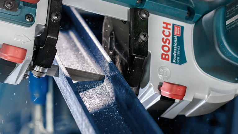 Metal cutting saw making a precise cut through a steel beam.