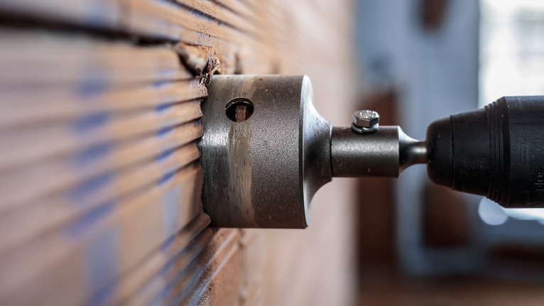 Hole saw drilling into a wall for precise circular cuts.