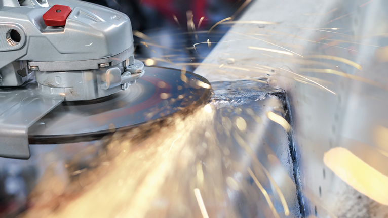 PRO Stainless Steel Grinding Disc, 100 x 6 x 16 mm Angle grinder cutting metal, producing sparks.