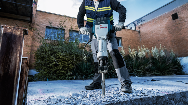 PRO HEX-4C Spade Chisel 28 mm, 80 x 400 mm Person wearing safety equipment breaks concrete with a heavy-duty demolition tool.