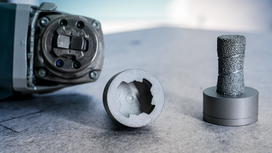 Rotary tool with a core bit and a grinding accessory placed on a work surface.