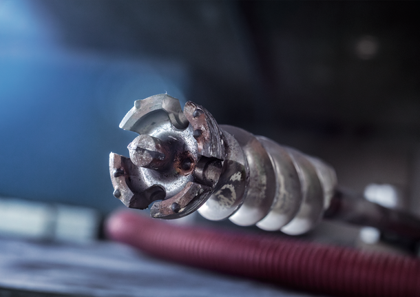 Close-up of a heavy-duty rotary hammer drill bit for concrete work.