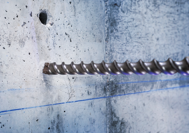 PRO SDS-max-7 Drill Bit, 35x400x520 mm Large masonry drill bit boring into a concrete wall.