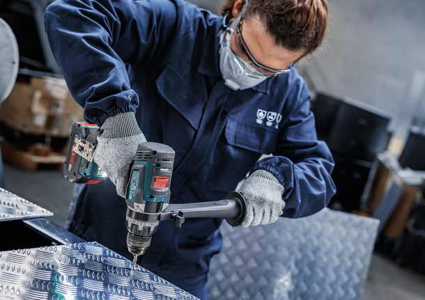 PRO Metal HSS-G Hex Twist Drill Bit Set, 5 pcs Person wearing safety equipment drills into a metal plate.