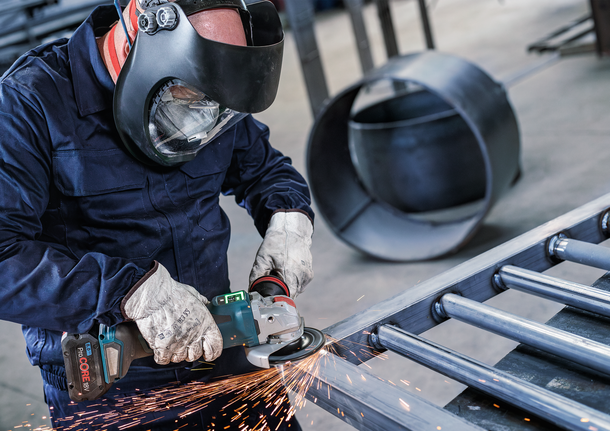 PRO Backing Pad Clip, X-Lock Person wearing safety equipment grinds metal, creating sparks.