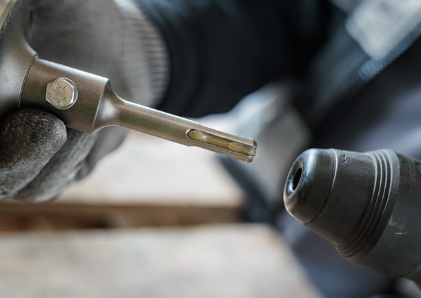 PRO SDS Shank Grease, for Drill and Chisel Person wearing safety equipment inserting a drill bit into a rotary hammer.