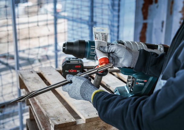 PRO SDS Shank Grease, for Drill and Chisel Person wearing safety equipment applies lubricant to a large drill bit.