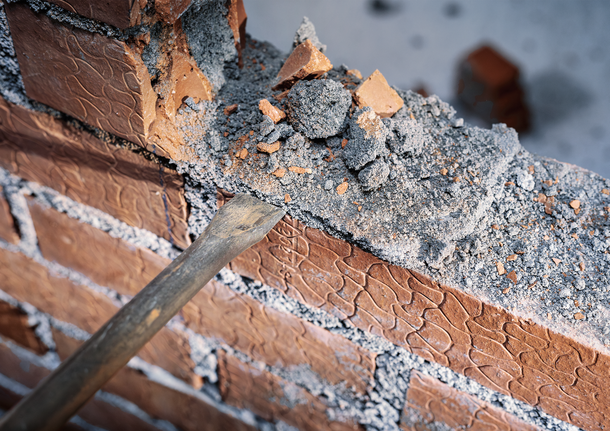 PRO SDS max-4C Flat Chisel, 25 x 600 mm Chisel breaking and removing mortar from the top of a brick wall.