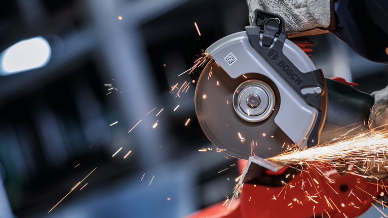 PRO Metal Bonded Cutting Disc, 125 x 2.5 x 22.23 mm, X-Lock, Straight A person wearing safety equipment grinds metal, producing bright sparks.