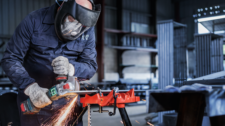 PRO Metal Bonded Cutting Disc, 125 x 2.5 x 22.23 mm, X-Lock, Straight Person wearing safety equipment uses a power tool to grind metal, creating sparks.