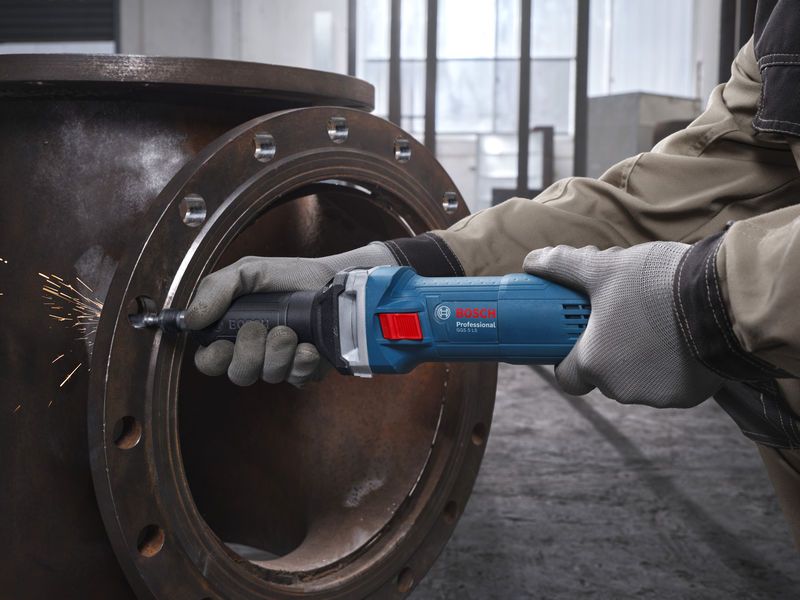 GGS 5 LS A person wearing safety equipment grinds a metal pipe with a straight grinder.