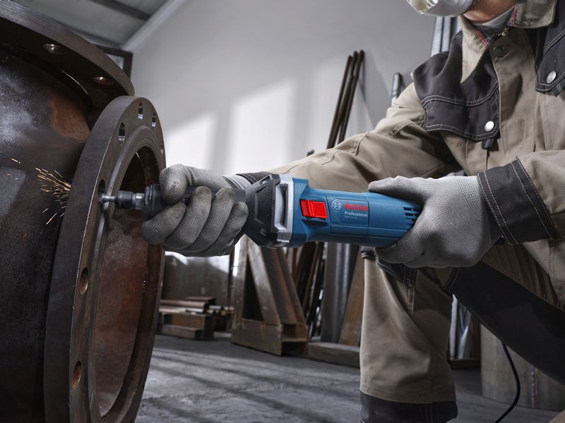 GGS 5 LS A person wearing safety equipment uses a straight grinder to grind the inside of a large metal pipe.