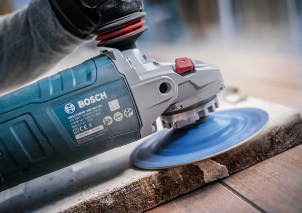 Bosch angle grinder with X-LOCK system sanding wood.