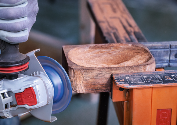 Bosch X-Lock angle grinder shaping wood.