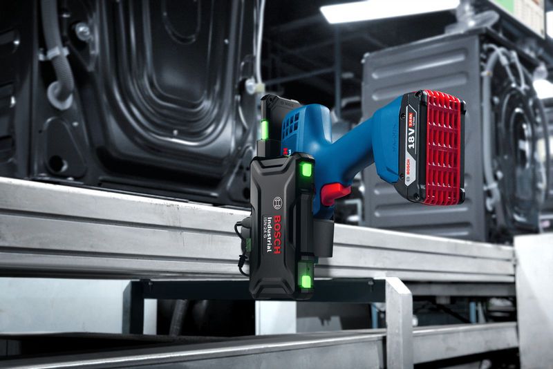 Cordless industrial smart controller mounted on a metal frame in a factory setting.