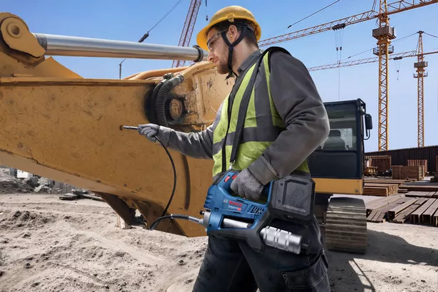 GFP 18V-10 A person wearing safety equipment uses a cordless caulk gun on construction machinery.