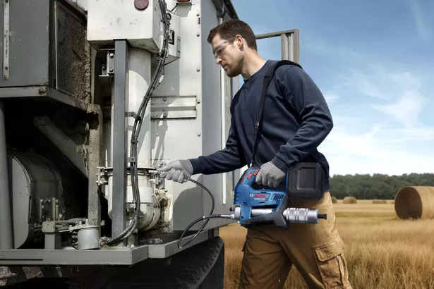 GFP 18V-10 A person wearing safety equipment uses a cordless caulk gun to seal machinery outdoors.