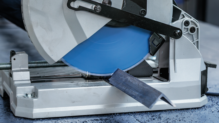 EXPERT Steel Circular Saw Blade, 305 x 2.6/2.2 x 25.4 mm, T60 Metal cutoff saw cutting through a steel bar on a workshop floor.