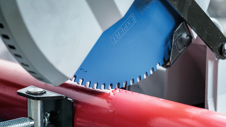 EXPERT Steel Circular Saw Blade, 305 x 2.6/2.2 x 25.4 mm, T60 Circular saw blade cutting through a red metal pipe in a workshop setting.