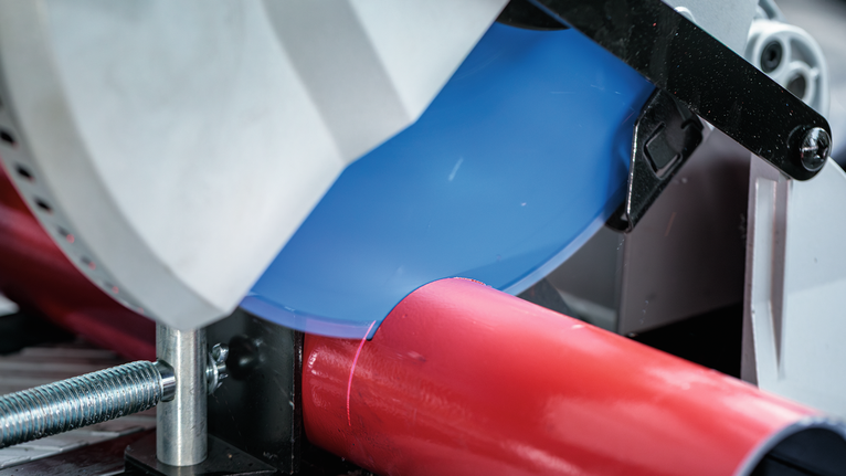 EXPERT Steel Circular Saw Blade, 305 x 2.6/2.2 x 25.4 mm, T60 Circular saw cutting through a red metal pipe in a workshop setting.