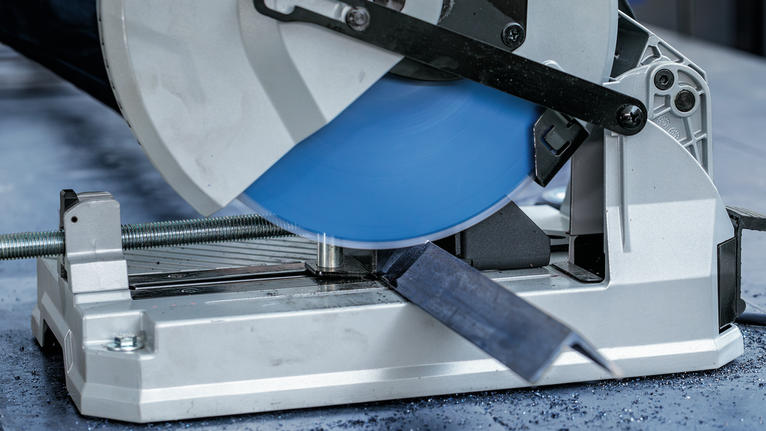 EXPERT Steel Circular Saw Blade, 305 x 2.6/2.2 x 25.4 mm, T60 Metal cutting saw slices through a steel bar on a workshop table.