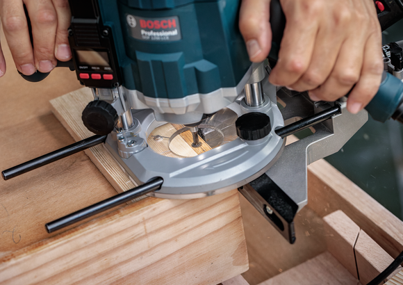 Object #200587584: 7437802_app_wide_02 Person guides a power router cutting a groove in a wooden board.