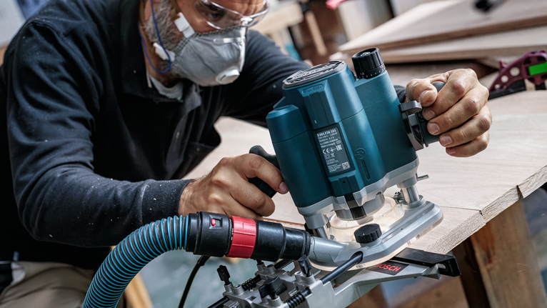 PRO Router Straight Bit, Two Flutes, Ø 1/4″ x L 5/8″, Shank 1/4″ Person wearing safety equipment uses a power router to shape the edge of a wooden board.