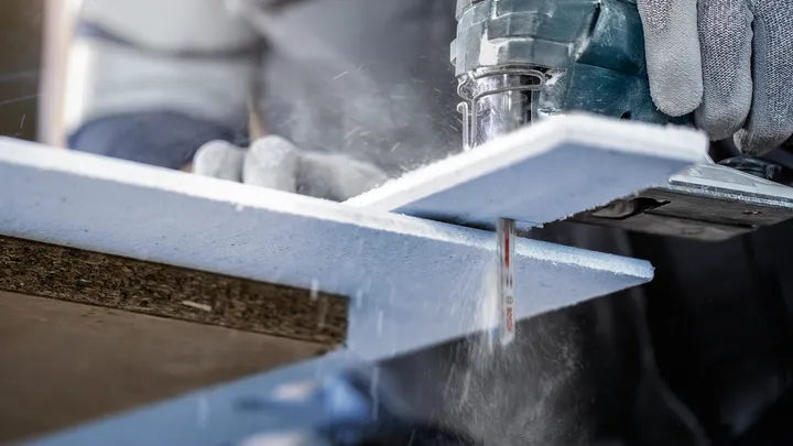 Object #200597856: 2793289_app_web_01 Person wearing safety equipment cuts a foam insulation board using a power jigsaw.