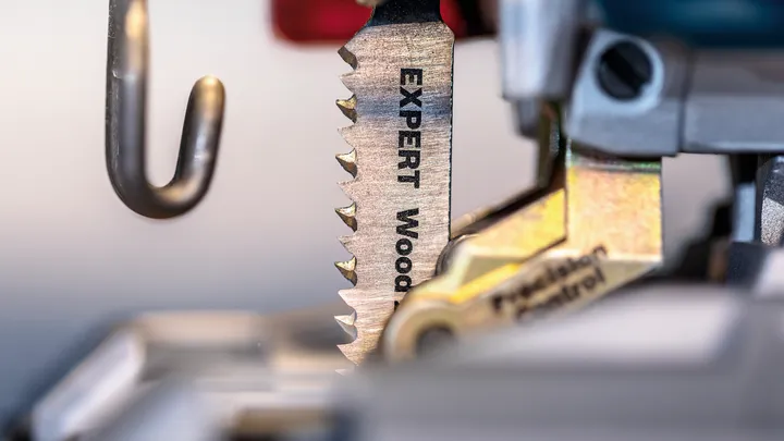 Object #200597868: 2793296_app_web_05 Jigsaw blade labeled for wood cutting clamped into a power tool.