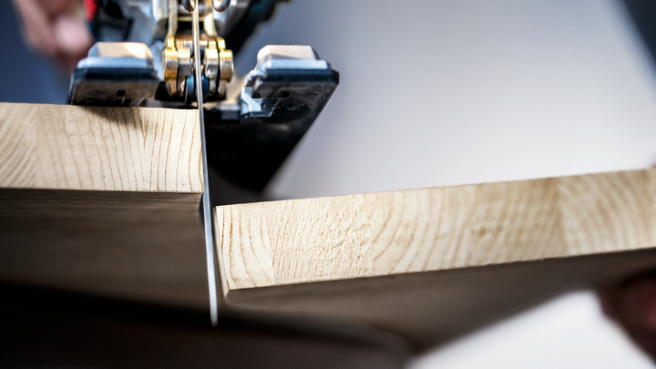 Object #200597877: 2793297_app_web_06 A person cuts a wooden board with a jigsaw.