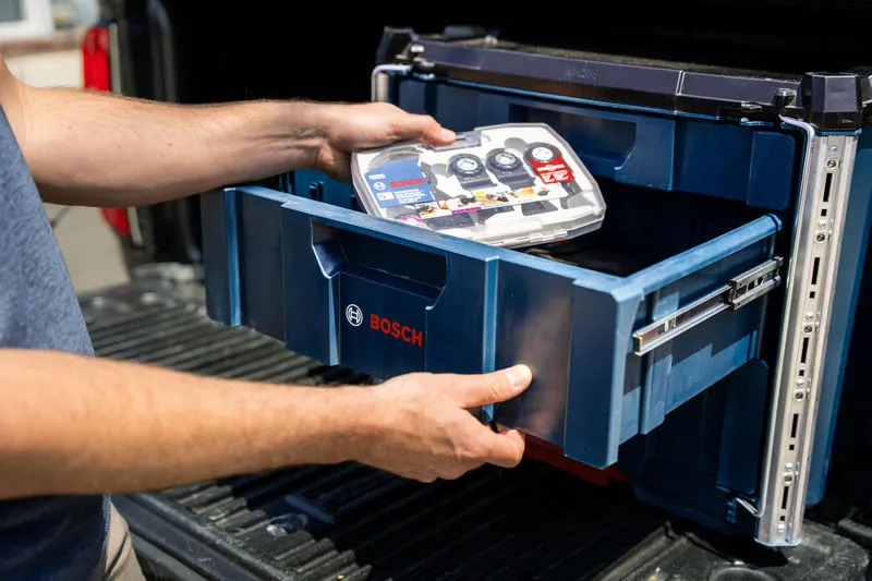 A person slides open a contractor drawer carrying case system to store a tool kit.