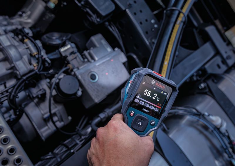 Person uses a thermo detector to check the temperature of machinery parts.
