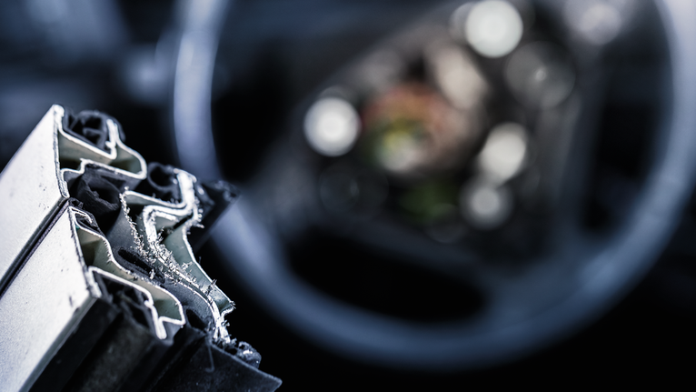 Close-up of freshly cut metal profiles with fine shavings on the edges.