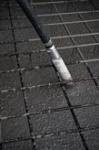 Concrete vibrator consolidating freshly poured concrete over a steel reinforcement grid.