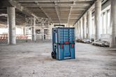 Rolling carrying case system with drawers stands in the middle of a construction site.